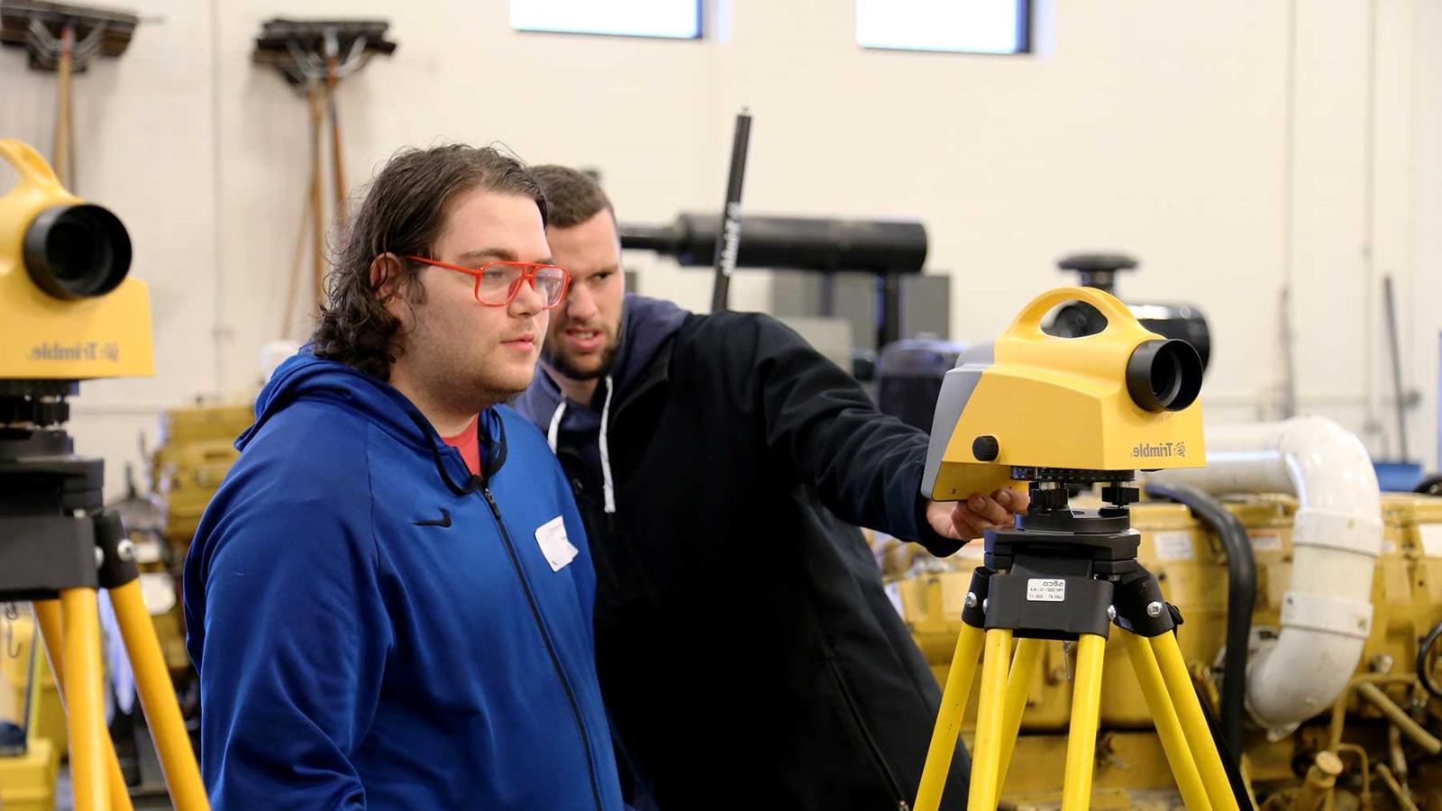 Two students looking at a digital level